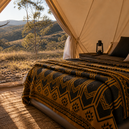 Wool Blanket with Aztec Pattern on a camping bed in Australian outback